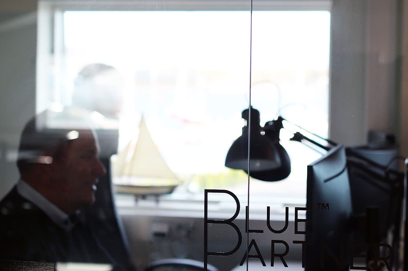 Blue Partners kontorsmiljö med logga på glasdörren